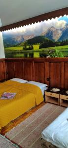 ein Schlafzimmer mit einem gelben Bett und einem Gemälde an der Wand in der Unterkunft Penzión Horec II in Ždiar