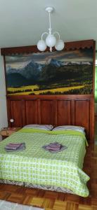 Schlafzimmer mit einem Bett mit Wandgemälde in der Unterkunft Penzión Horec II in Ždiar