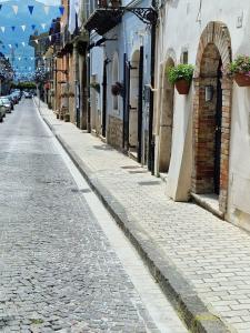 uma rua de calçada com edifícios e vasos de plantas em Il Corso em Montesarchio