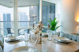 a dining room table with plates and wine glasses at Veluxa - Stylish 2 Bed with View in Dubai