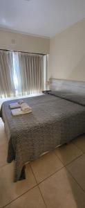 a bedroom with a large bed with a large window at Hotel Bertiami in Mar del Plata