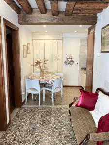uma sala de jantar com uma mesa e cadeiras brancas em San Bortolomio near Suso Ice-cream em Veneza