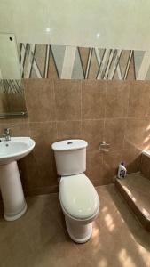 a bathroom with a toilet and a sink at MatKay 3 bedroom House in Oyibi