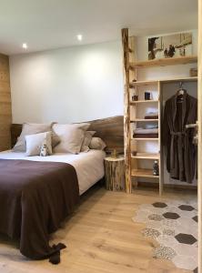 a bedroom with a bed and a shelf with clothes at La marmotte qui papote in Le Grand-Bornand