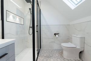 a white bathroom with a toilet and a shower at Spacious & Modern Two Bedroom Apartment in Catford, London in Catford +13 photos