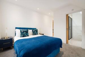 ein Schlafzimmer mit einem blauen Bett und einer blauen Decke in der Unterkunft Spacious & Modern Two Bedroom Apartment in Catford, London in Catford