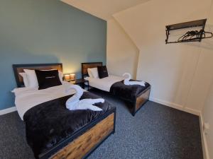 two beds with swans on them in a room at 3 bedroom Urban Retreat Near Bike Park Wales in Merthyr Tydfil