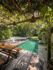 an outdoor pool with a table and a pergola at Medusa Bungalow - Galle in Galle