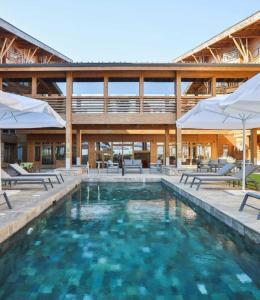 una piscina con sillas y sombrillas en Spacious penthouse chalet apartment in Pirin Golf and Country Club en Razlog