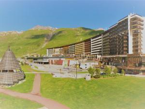 une vue d'un bâtiment avec des montagnes en arrière-plan dans l'établissement Studio cosy à Tignes, au pied des pistes et commerces - FR-1-411-481, à Tignes