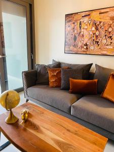 sala de estar con sofá y mesa de madera en NEW 2BDR apartment with SHARED ROOFTOP POOL, en Atenas