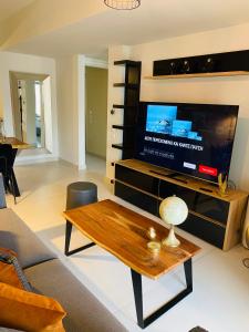 a living room with a tv and a coffee table at NEW 2BDR apartment with SHARED ROOFTOP POOL in Athens