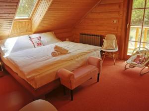 a bedroom with a large bed and a chair at Pohádkový Srub Salaš in Salaš