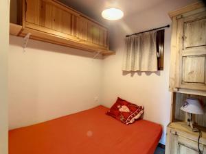 ラ・トゥッスイールにあるAppartement La Toussuire, 2 pièces, 4 personnes - FR-1-417-12の赤いベッドと窓が備わる小さな客室です。