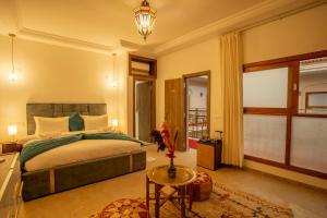 - une chambre avec un grand lit et une table dans l'établissement Riad Kenza, à Marrakech