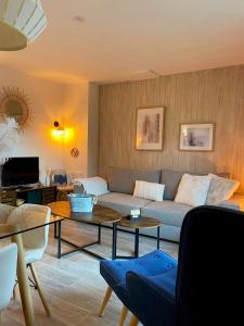 uma sala de estar com um sofá e uma mesa em Chalet de 3 chambres a Le Devoluy a 200 m des pistes avec piscine partagee sauna et balcon em Le Dévoluy