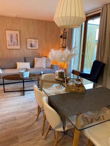uma sala de estar com um sofá, uma mesa e cadeiras em Chalet de 3 chambres a Le Devoluy a 200 m des pistes avec piscine partagee sauna et balcon em Le Dévoluy