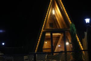 una casa en el árbol por la noche con luces encendidas en Pagen Bungalow, en Hopa