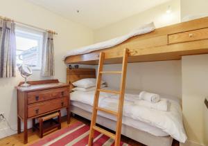 a bedroom with a bunk bed and a desk at Wayfarer Cottage in Woodbridge