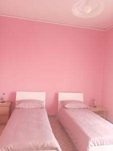two beds in a room with pink walls at B&B - Antonietta & Friends in Mercato San Severino
