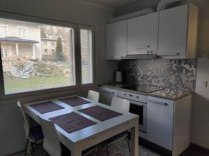 a kitchen with a table with chairs and a window at 3 Bedroom Duplex apartment in Helsinki