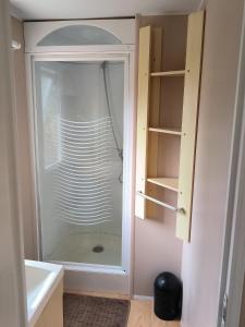 a glass shower door in a bathroom next to a sink at Mira Monti Location in Belvédère