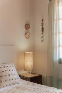 um quarto com uma cama, um candeeiro e uma janela em Pousada Vila Campeche em Florianópolis
