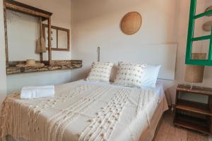 1 dormitorio con 1 cama con sábanas y almohadas blancas en Pousada Vila Campeche, en Florianópolis