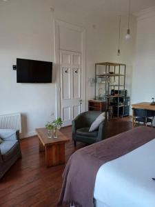 a bedroom with a bed and a couch and a table at Apartamentos Cerro Alegre in Valparaíso