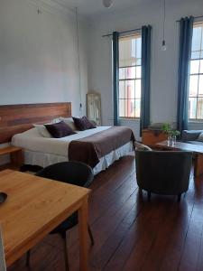una camera con letto, tavolo e sedie di Apartamentos Cerro Alegre a Valparaíso