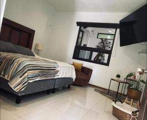 een slaapkamer met een bed en een spiegel aan de muur bij Casa Terrazas Gardel in Guanajuato