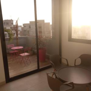 a room with a balcony with a table and chairs at RÉSIDENCES MOROLA - SENA in Dakar