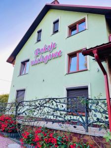 a building with a sign on the side of it at Pokoje noclegowe KASZTEL - Łowisko in Łowisko