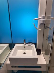 a white sink in a bathroom with a blue light at Victoria Hotel in Nafplio