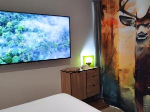 a bedroom with a tv and a painting on the wall at El Cielo de Cebreros in Cebreros