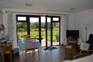 a living room with sliding glass doors and a table and chairs at Smithfield Farm Bed & Breakfast in Builth Wells