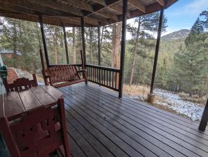 a screened in porch with two benches and a table at Park-like setting in-law apartment less than a mile to Evergreen in Evergreen