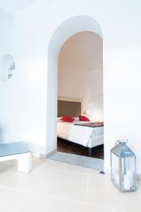 a white bedroom with a bed and a table at Marina 10 Boutique&Design Hotel in Ischia