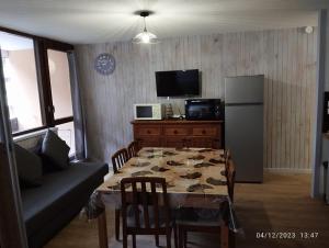 a living room with a table and a refrigerator at Proches des pistes F2 36m2 4-6 pers 2 étoiles in Besse-et-Saint-Anastaise