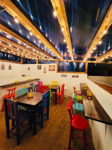 une salle à manger avec des tables et des chaises colorées dans l'établissement Suites del Barrio, à San Cristóbal de Las Casas