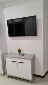 um armário branco com uma televisão na parede em Up Sal em Aveiro