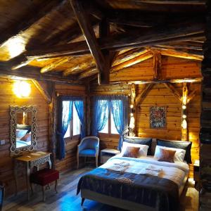 una camera da letto in una baita di tronchi con letto e specchio di Antalya Bodrum Kayası Dağ Oteli a Hasdümen