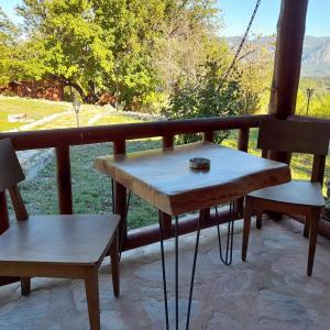 einen Tisch und zwei Bänke auf einem Balkon mit Aussicht in der Unterkunft Antalya Bodrum Kayası Dağ Oteli in Hasdümen