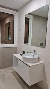 a white bathroom with a sink and a mirror at Up Sal in Aveiro