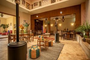 a large living room with tables and chairs at Riad Azia in Marrakesh