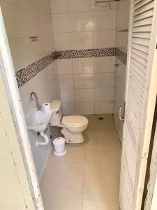 La salle de bains est pourvue de toilettes et d'un lavabo. dans l'établissement Chácara Recanto dos pássaros, à Bairro das Rosas