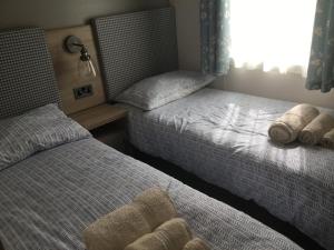 1 Schlafzimmer mit 2 Betten und einem Fenster in der Unterkunft Lakeside Holiday Home in Hastings