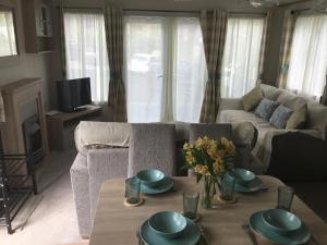 a living room with a couch and a table at Lakeside Holiday Home in Hastings