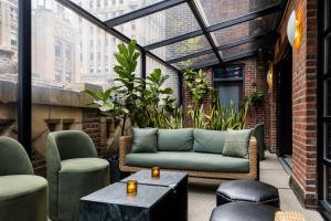 a patio with a couch and two chairs and a table at Library Hotel by Library Hotel Collection in New York