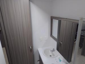 a bathroom with a sink and a mirror at OroNegroApartaHoteles Espectacular Apartaestudio Amoblado Armenia, Quindio in Armenia
